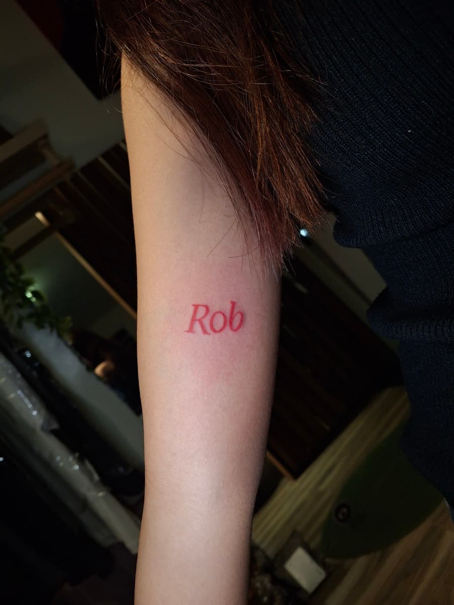 minimalist red ink name script forearm tattoo by isaiah recongco — gorillaz tattoo art studio philippines